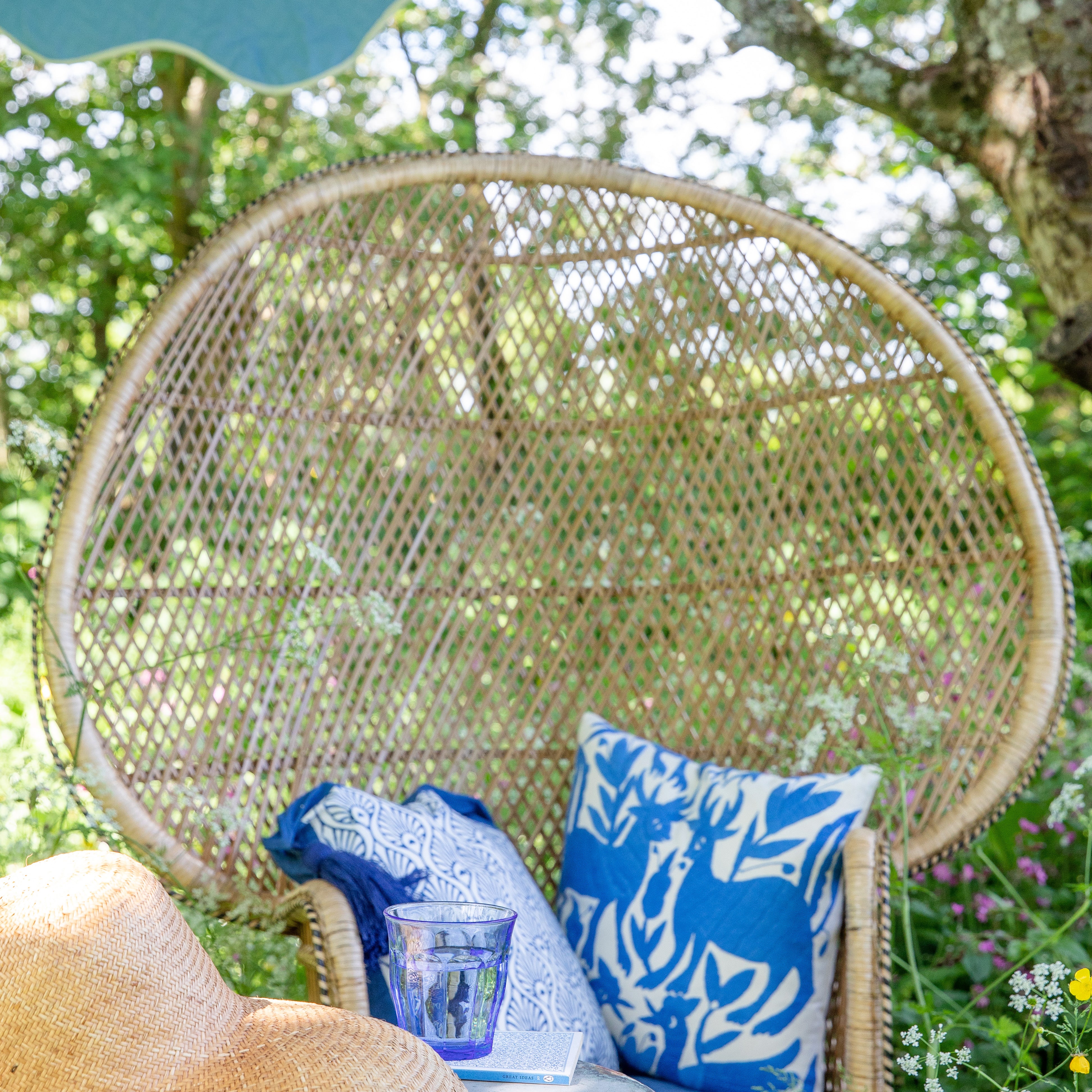 Peacock chair with Indigo Suzani cushion and beautiful garden decor. This is a fantastic parasol that will brighten up every occasion.