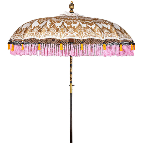 Helena Round Bamboo Parasol - soft beige twill with lotus design hand-painted in gold ink. Inside the threading is vibrant tangerine orange, and the fringe is a combination of peony pink, black and orange tassels. The pole is made from hand-carved durian wood pole with gold paint and finial, the pole join and pegs are made from solid brass.