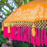 Etta. Vibrant orange Bali garden parasol, artisan painted with gold and with handmade pink fringing. The most beautiful garden umbrella and summer accessory. Perfect for patios, pools, picnics and weddings. The ultimate stylish garden decoration, luxurious, colourful and handmade.