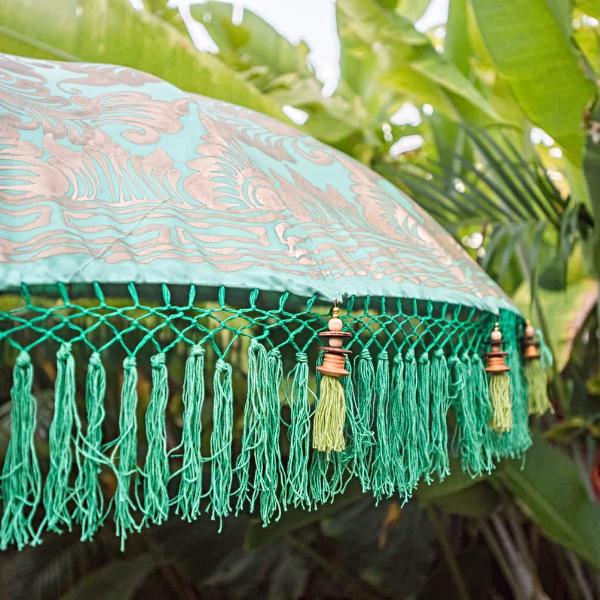 Tracy Round Bamboo Parasol - Beautiful light green twill garden parasol with lotus design hand-painted in gold ink. The pole is made from hand-carved durian wood pole with gold paint and finial, the pole join and pegs are made from solid brass. The parasol has muted turquoise threading and bamboo spokes. Hand-made green and light blue fringing, with beaded green tassels.