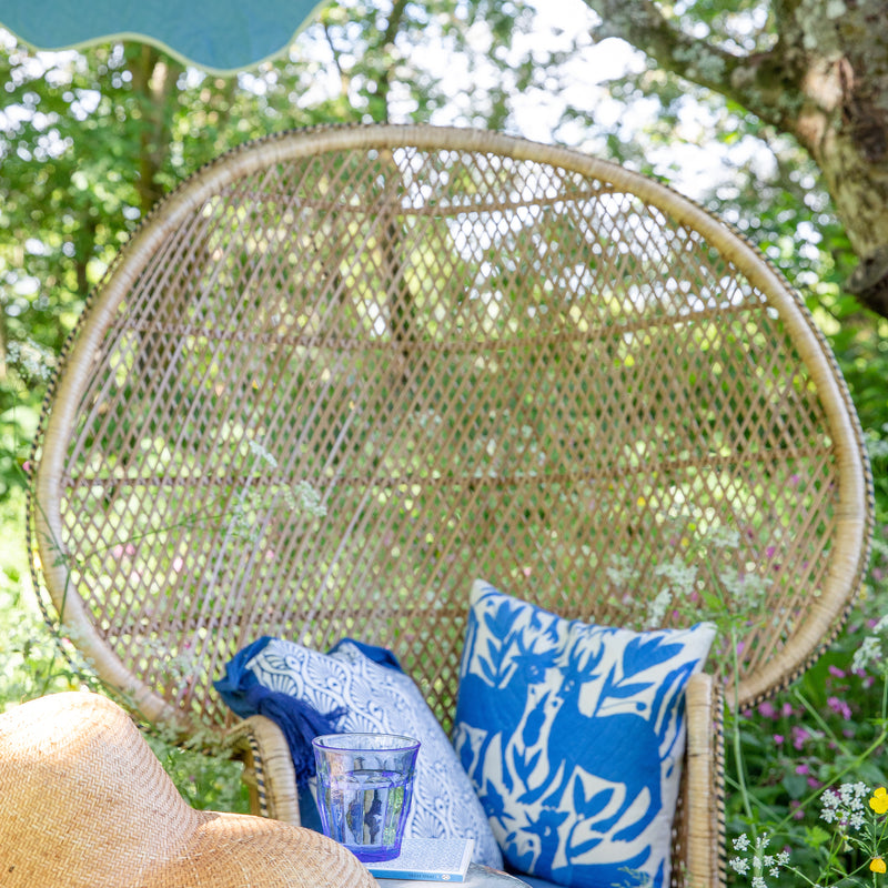 Peacock chair with Indigo Suzani cushion and beautiful garden decor. This is a fantastic parasol that will brighten up every occasion. 