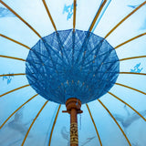 East London Parasol Company Bali Bamboo 2m garden umbrella. Flying birds cranes with white, blue and indigo. Handmade and handpainted with fringing and tassels in shades of white