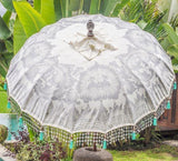 Cher white cream silver and mint green blue  garden parasol or umbrella hand painted with silver. Bamboo spokes, hand carved durian wood pole, Indian metal silver fringing and light blue cotton tassels. Pretty garden umbrella for picnics, gardens, festivals, weddings, terraces and pool side. Beautiful boho, bali parasol.