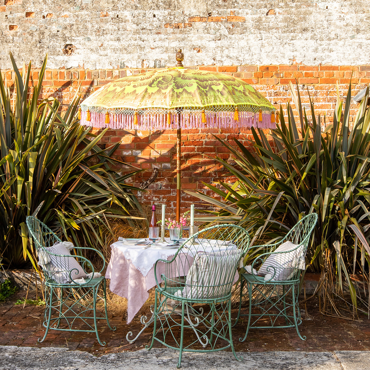 Dayla Round Bamboo Parasol has orange threading inside and bamboo spokes. The pole is made from hand-carved durian wood pole with gold paint and finial, the pole join and pegs are made from solid brass. The fringing is in pink with elegant orange tassels and gold beading.