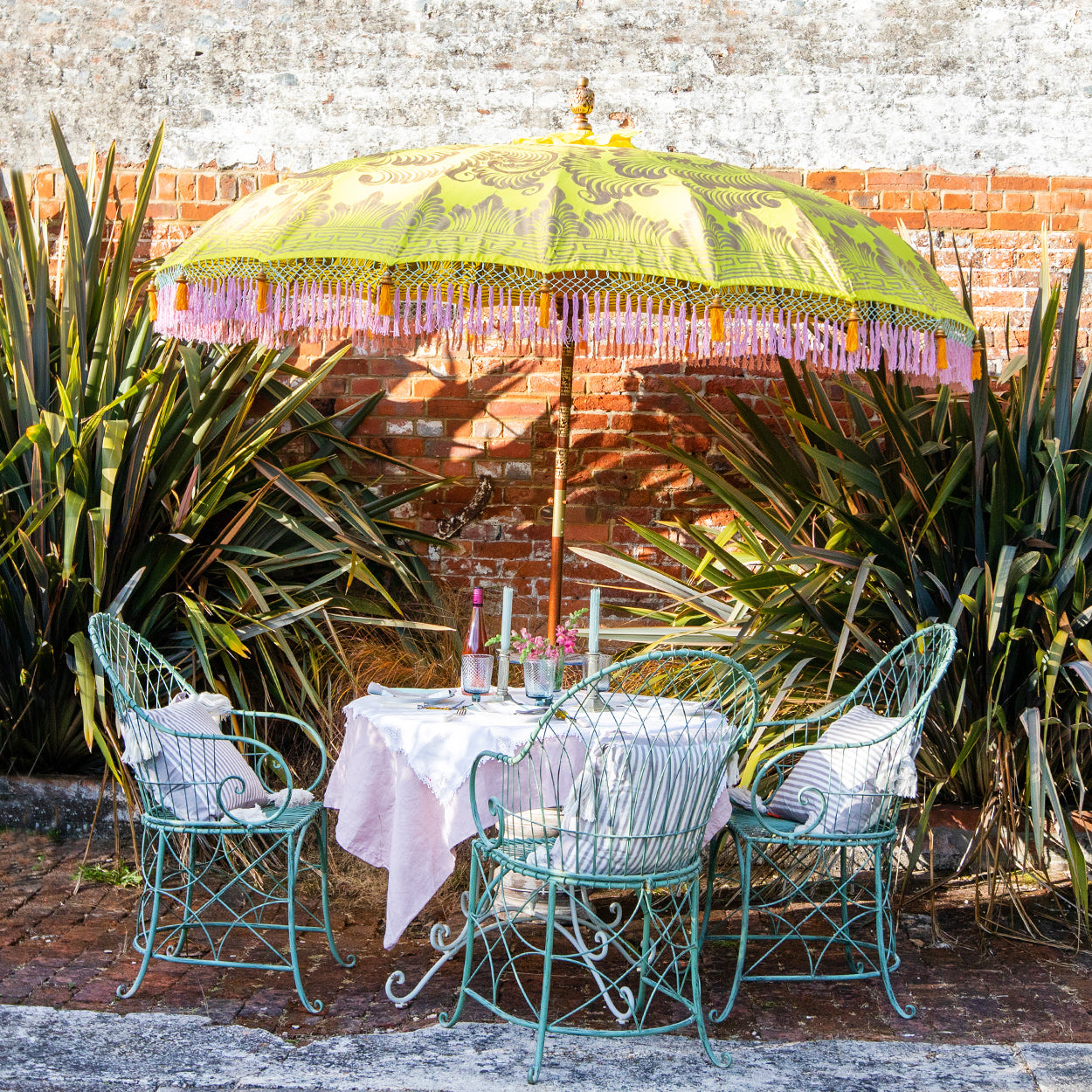 Dayla Round Bamboo Parasol has orange threading inside and bamboo spokes. The pole is made from hand-carved durian wood pole with gold paint and finial, the pole join and pegs are made from solid brass. The fringing is in pink with elegant orange tassels and gold beading.