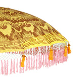 Dayla Round Bamboo Parasol has orange threading inside and bamboo spokes. The pole is made from hand-carved durian wood pole with gold paint and finial, the pole join and pegs are made from solid brass. The fringing is in pink with elegant orange tassels and gold beading.