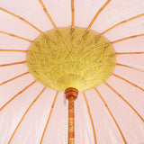 Grace Round Bamboo Parasol is elegant white canopy with green polka dots. Yellow threading inside and bamboo spokes. The pole is made from hand-carved durian wood pole with gold paint and finial, the pole join and pegs are made from solid brass. The fringing is in white with sophisticated white tassels and beading.