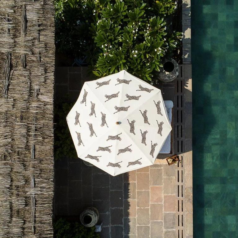 In stock 3m width Waterproof canvas Big Gloria garden umbrella. Leopard printed garden parasol with neutral beige and creams. A show stopping garden umbrella with wooden frame and tassels. The perfect umbrella for gardens, summer, patios, pool side and terraces. On the leopard print, maximalism animal safari trend.