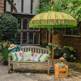 East London Parasol Jane parasol- lime green Bali bamboo 2m garden umbrella with lotus design hand painted in gold ink. Tassels in shades of green and pink, hand made. A beautiful, colourful and luxurious garden decoration to suit any pool, dining table, wedding or cocktail patio. A stylish summer accessory.