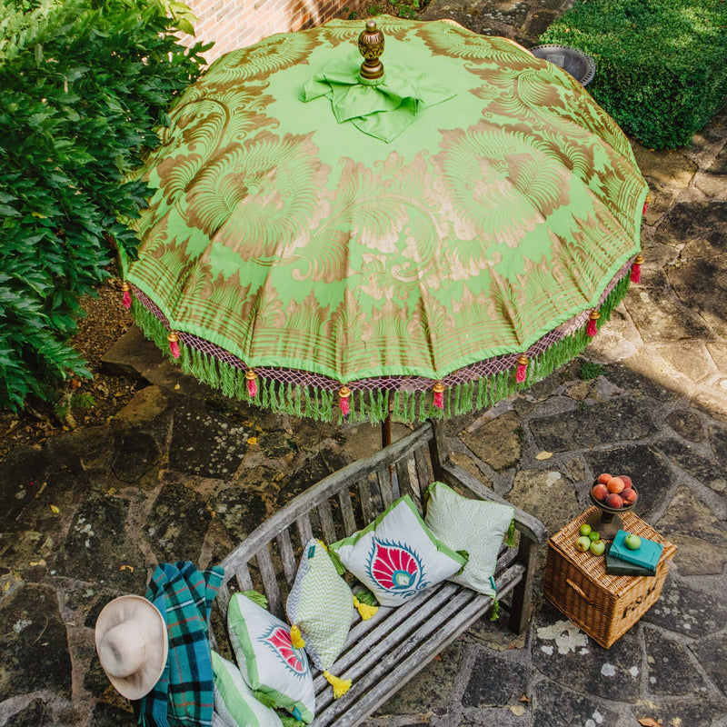 Jane Round Bamboo Parasol - Light lime green twill with lotus design hand-painted in gold ink. Matching green threading and bamboo spokes. The pole is made from hand-carved durian wood pole with gold paint and finial, the pole join and pegs are made from solid brass. Fringing in shades of green with bright light pink tassels.