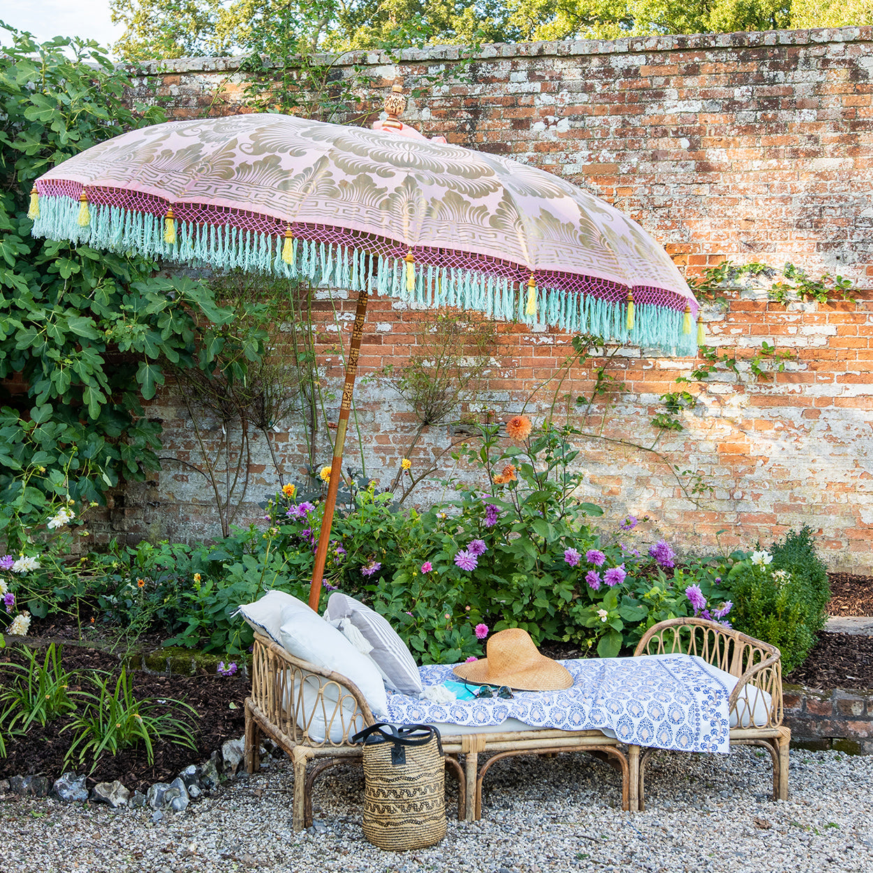 3m Rosanna Round Bamboo Parasol's canopy is a gorgeous pastel pink with lotus design hand-painted in gold ink.  Inside the threading is light yellow, and the fringe is a combination of mint green and light yellow tassels. The pole is made from hand-carved durian wood pole with gold paint and finial, the pole join and pegs are made from solid brass.