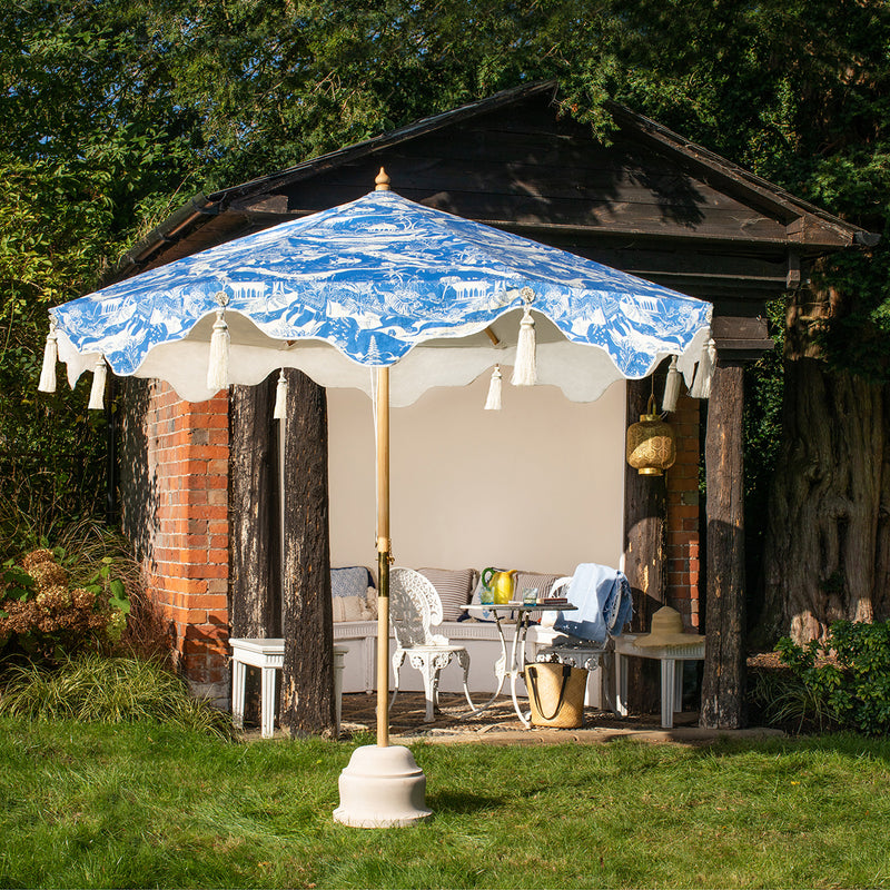 Handcrafted frame made in the UK. Natural cotton canvas with printed blue and white East London Parasol Company's story outside and white inside, and scalloped valance- in collaborated with V&A exhibited British artist Harriet Popham. 