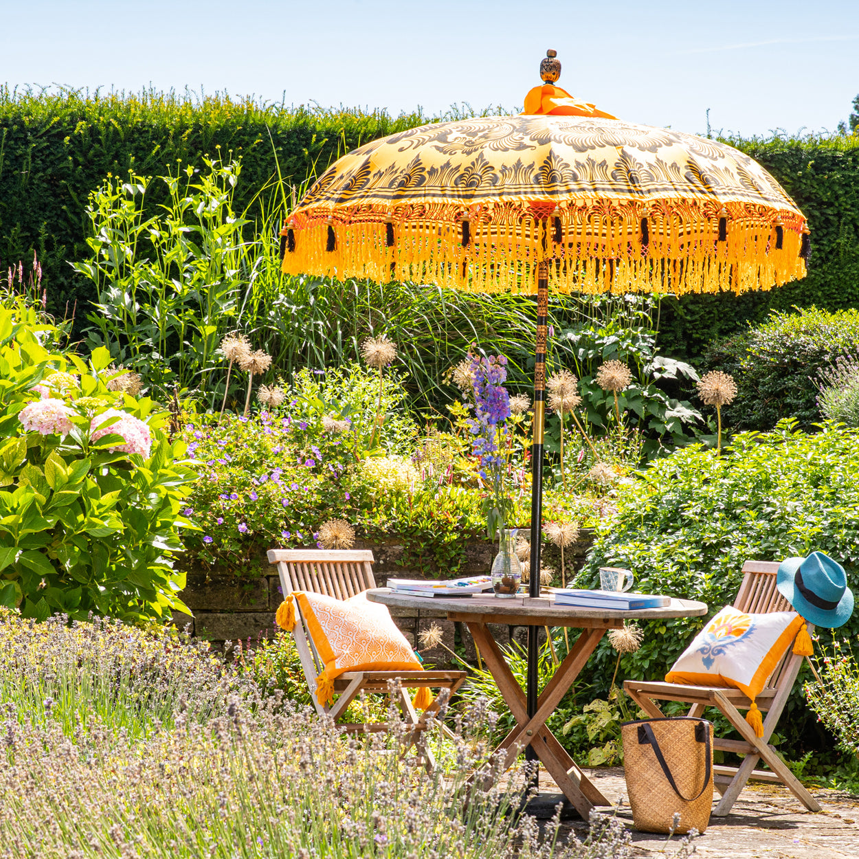 Augusta Round Bamboo Parasol has dark orange threading inside and bamboo spokes. The pole is made from hand-carved durian wood pole with gold paint and finial, the pole join and pegs are made from solid brass. The fringing is in orange with yellow tassels and beading. These are handmade items and there may be some variation in colour.