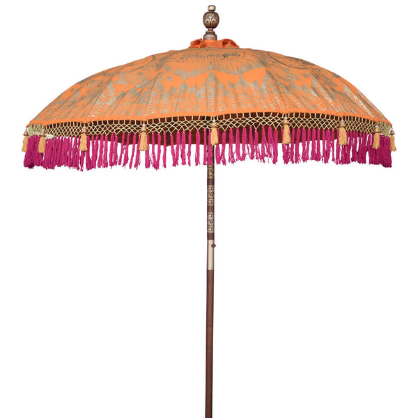 Etta Round Bamboo Parasol is a vibrant tangerine twill with lotus design hand-painted in gold ink. Fuchsia pink threading with hints of yellow, bamboo spokes. The pole is made from hand-carved durian wood pole with gold paint and finial, the pole join is made from solid brass. The parasol canopy is finished with hand-made pink fringing with beaded sunset orange tassels.
