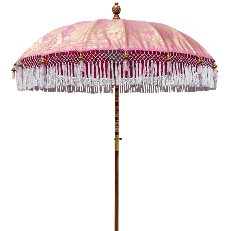 Heidi Round Bamboo Parasol is a blossom pink twill umbrella with lotus design hand-painted in gold ink. White threading inside and bamboo spokes. The pole is made from hand-carved durian wood pole with gold paint and finial, the pole join and pegs are made from solid brass. The fringing is in white with gorgeous white tassels and gold beading.