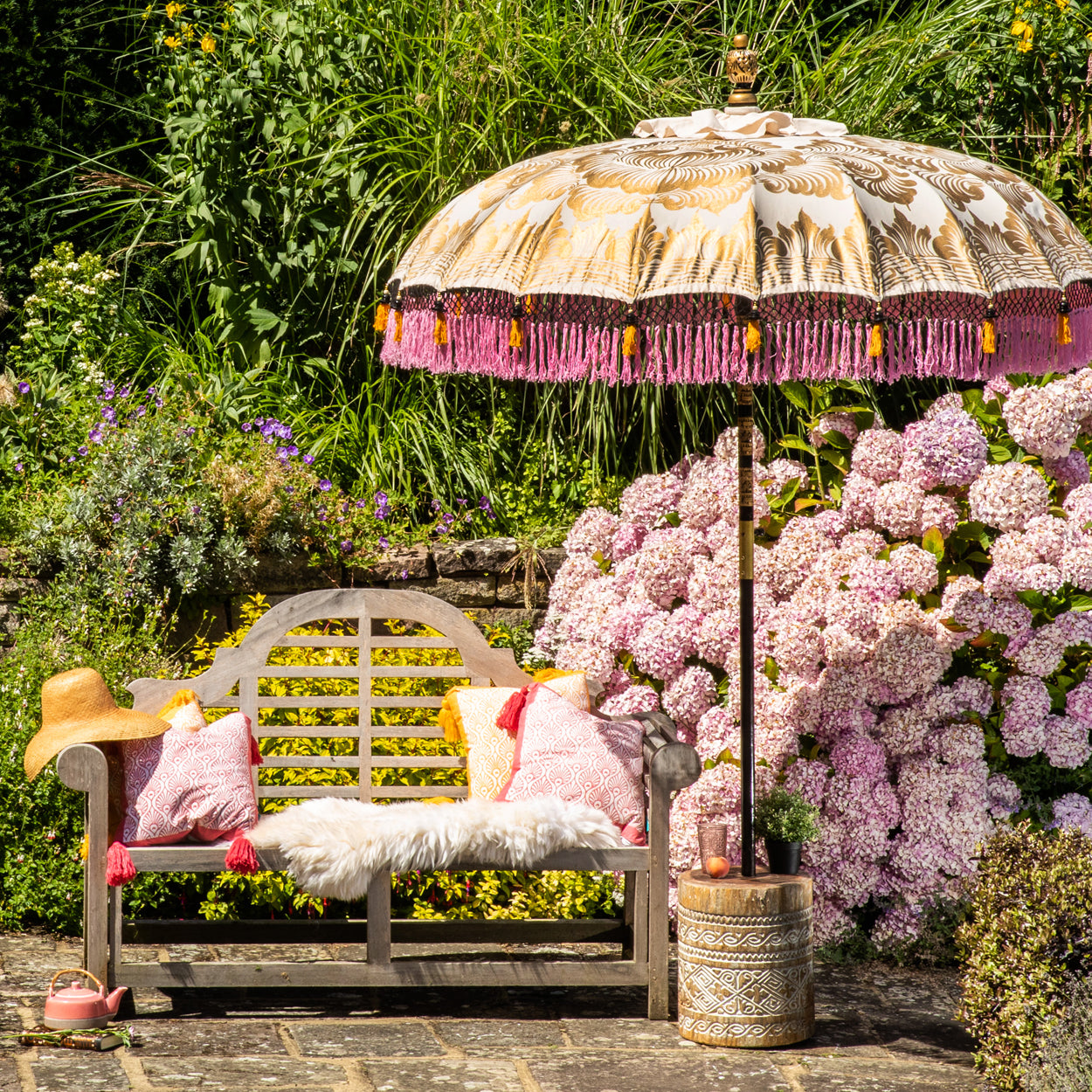 Helena Round Bamboo Parasol - soft beige twill with lotus design hand-painted in gold ink. Inside the threading is vibrant tangerine orange, and the fringe is a combination of peony pink, black and orange tassels.