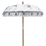 Lexi Round Bamboo Parasol -Digitally printed off-white with a design of soaring cranes in shades of indigo and grey, inspired by Japanese woodcuts. The parasol is printed on waterproof canvas, lined with heavenly blue with French-blue threading and bamboo spokes. The pole is made from hand-carved durian wood pole with gold paint and finial, the pole join and pegs are made from solid brass.